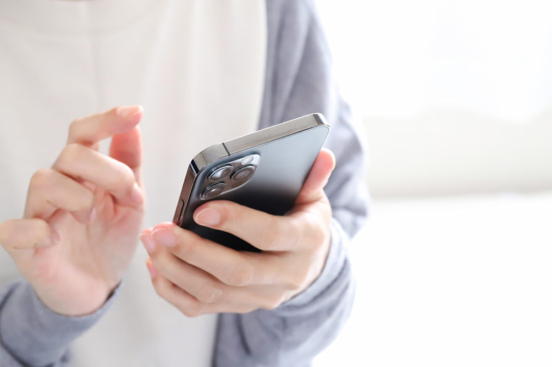 スマートフォンを操作する手元